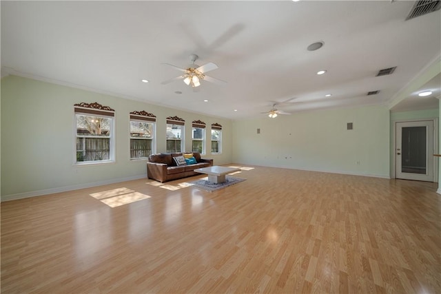 unfurnished living room featuring ceiling fan, ornamental molding, and light wood-type flooring