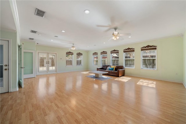 unfurnished living room featuring ornamental molding, french doors, ceiling fan, and light wood-type flooring