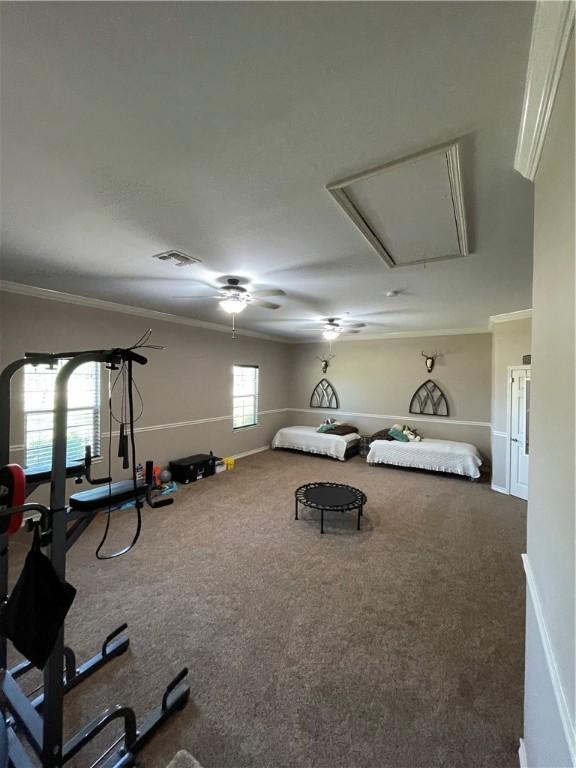 bedroom featuring crown molding, visible vents, baseboards, attic access, and carpet