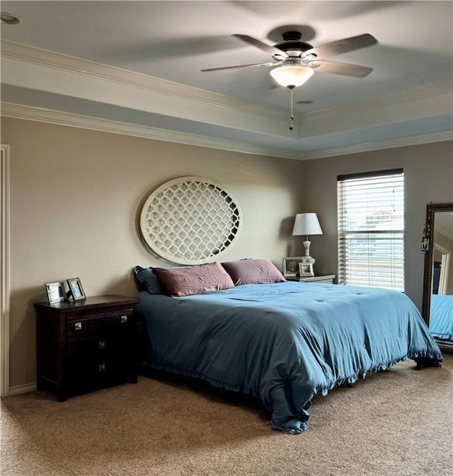 bedroom featuring crown molding, carpet flooring, ceiling fan, and a tray ceiling