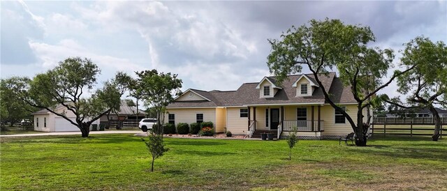 new england style home featuring fence, covered porch, and a front yard