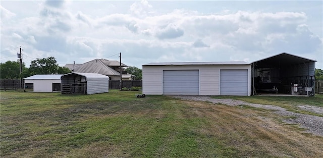 garage with a detached garage and fence