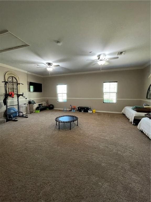 interior space with attic access, crown molding, ceiling fan, and visible vents