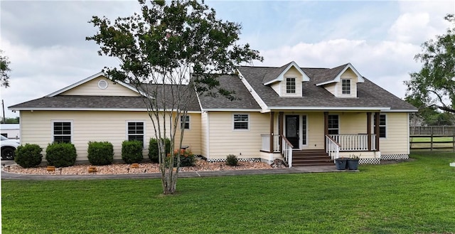 cape cod-style house featuring a porch, a front yard, a shingled roof, and fence