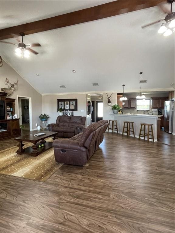 living room featuring dark wood finished floors, vaulted ceiling with beams, a ceiling fan, and ornamental molding