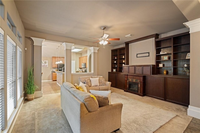 7437 Long S Dr, Corpus Christi, TX 78414 - living area with a glass covered fireplace, light colored carpet, plenty of natural light, and decorative columns