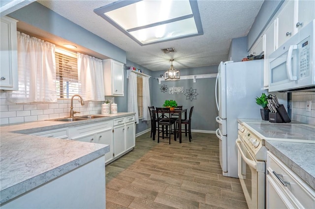 4318 Pecan Bayou Ct, Corpus Christi, TX 78410 - kitchen featuring sink, light hardwood / wood-style flooring, hanging light fixtures, white appliances, and white cabinets