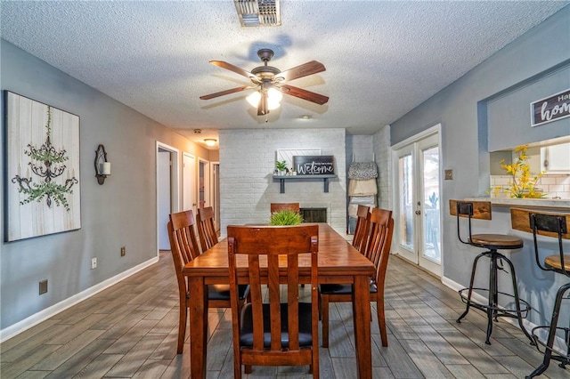 4318 Pecan Bayou Ct, Corpus Christi, TX 78410 - dining room featuring ceiling fan, a fireplace, a textured ceiling, and french doors