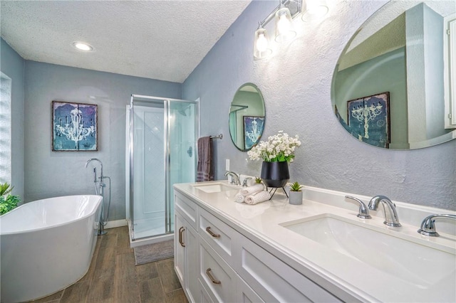 4318 Pecan Bayou Ct, Corpus Christi, TX 78410 - bathroom featuring hardwood / wood-style flooring, vanity, independent shower and bath, and a textured ceiling