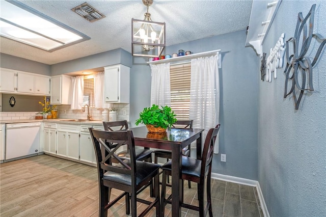 4318 Pecan Bayou Ct, Corpus Christi, TX 78410 - dining space featuring sink, a textured ceiling, light hardwood / wood-style floors, and a chandelier