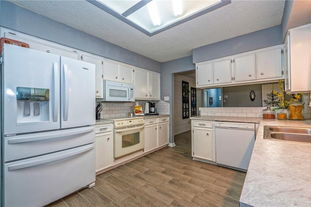 4318 Pecan Bayou Ct, Corpus Christi, TX 78410 - kitchen featuring white cabinetry, tasteful backsplash, light hardwood / wood-style flooring, a textured ceiling, and white appliances