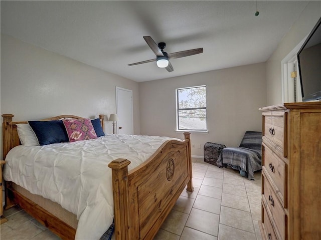 bedroom featuring light tile patterned floors, a ceiling fan, and baseboards