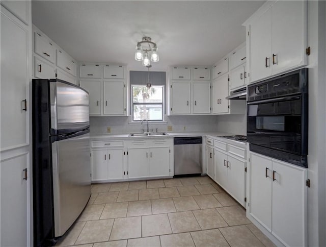 kitchen featuring appliances with stainless steel finishes, a sink, white cabinets, light tile patterned floors, and under cabinet range hood