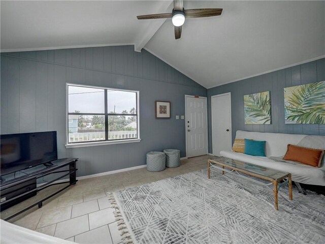 living room featuring tile patterned flooring, a ceiling fan, baseboards, and wooden walls