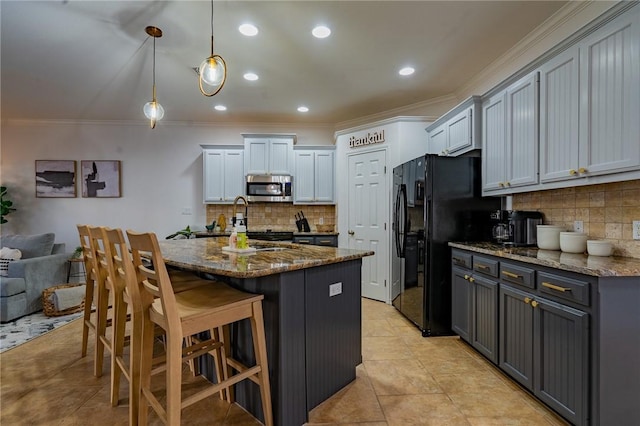 14878 Granada Dr Unit 403, Corpus Christi, TX 78418 - kitchen with dark stone countertops, stainless steel microwave, ornamental molding, and freestanding refrigerator