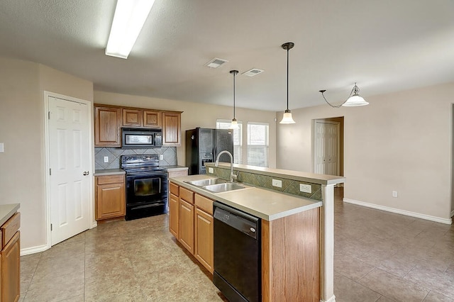 2334 Mystic Star Dr, Corpus Christi, TX 78414 - kitchen featuring black appliances, backsplash, light countertops, a center island with sink, and decorative light fixtures