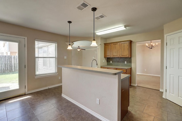2334 Mystic Star Dr, Corpus Christi, TX 78414 - kitchen featuring a chandelier, light countertops, decorative backsplash, light tile patterned flooring, and pendant lighting