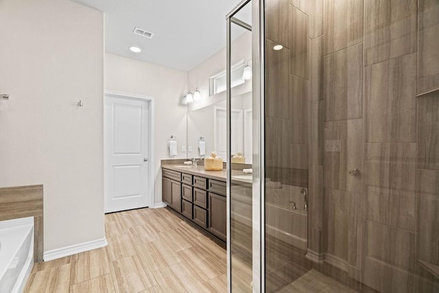 bathroom with vanity and shower with separate bathtub