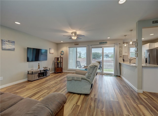 living room featuring ceiling fan and light hardwood / wood-style floors