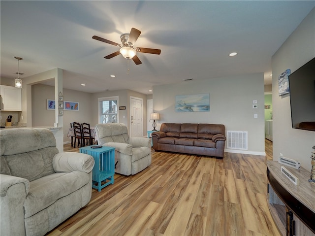 living room featuring ceiling fan and light hardwood / wood-style floors