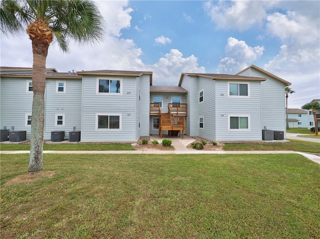 rear view of property featuring a yard, a deck, and cooling unit