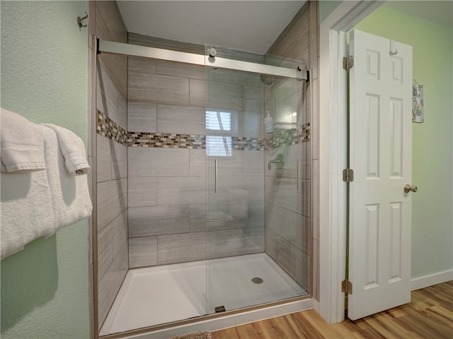 bathroom featuring hardwood / wood-style flooring and a shower with door