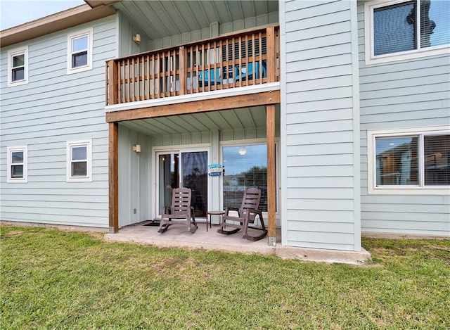 back of house with a patio, a yard, and a balcony