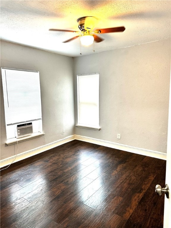 empty room with a textured ceiling, ceiling fan, cooling unit, and dark wood-type flooring