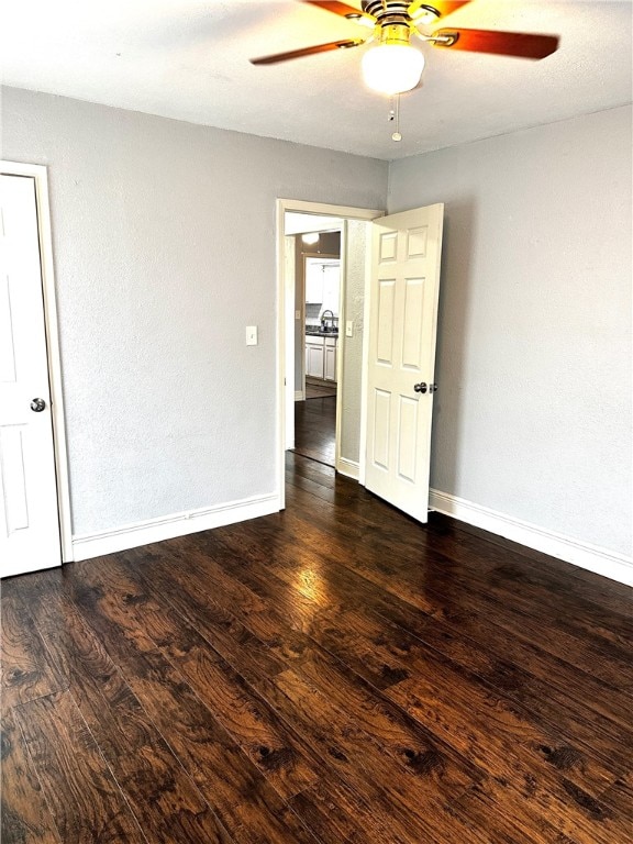 unfurnished room featuring dark hardwood / wood-style flooring and ceiling fan