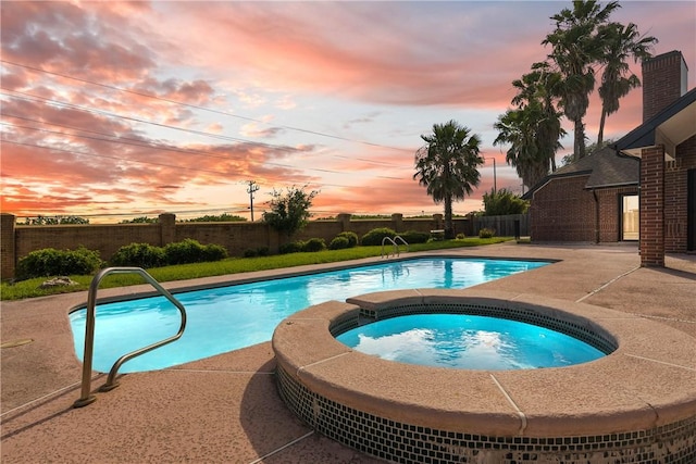 5913 Woodmere Dr, Corpus Christi, TX 78414 - pool at dusk featuring an in-ground hot tub, a fenced backyard, and a patio area