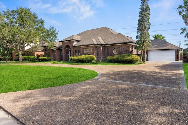 5913 Woodmere Dr, Corpus Christi, TX 78414 - view of front facade featuring a front lawn, brick siding, a garage, and roof with shingles