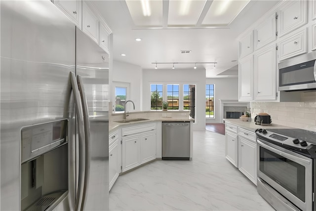 5913 Woodmere Dr, Corpus Christi, TX 78414 - kitchen with appliances with stainless steel finishes, a sink, a peninsula, white cabinets, and tasteful backsplash