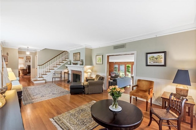 144 Cordula St, Corpus Christi, TX 78411 - living area with wood finished floors, crown molding, a wainscoted wall, and a fireplace