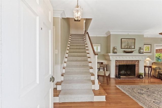 144 Cordula St, Corpus Christi, TX 78411 - entrance foyer with wood finished floors, stairs, a chandelier, a fireplace, and crown molding