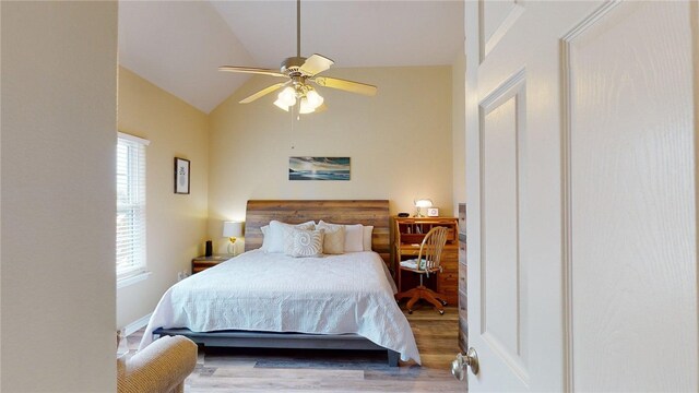 bedroom with ceiling fan, vaulted ceiling, and wood finished floors