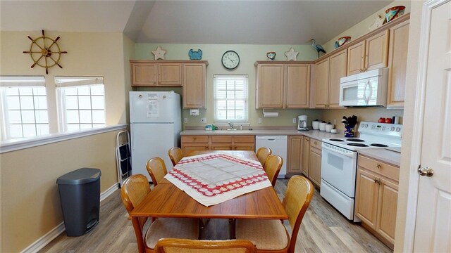 kitchen featuring light brown cabinetry, light countertops, baseboards, light wood finished floors, and white appliances