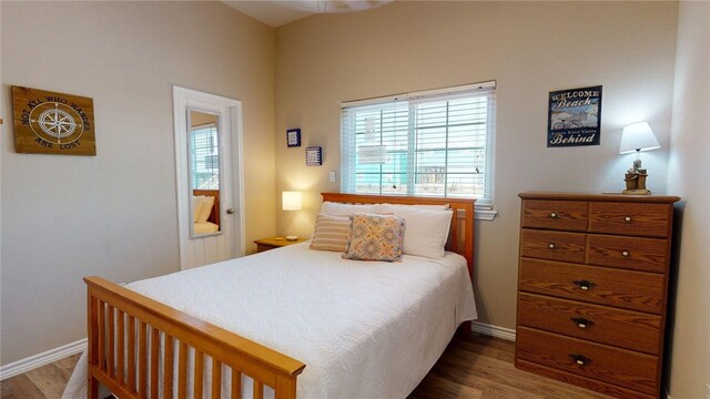 bedroom with baseboards and wood finished floors