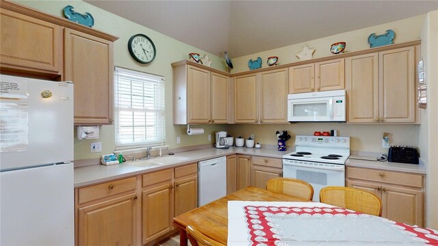 kitchen featuring light brown cabinets, white appliances, light countertops, a sink, and vaulted ceiling