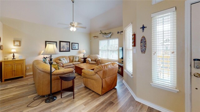 living room featuring baseboards, a ceiling fan, light wood finished floors, and high vaulted ceiling