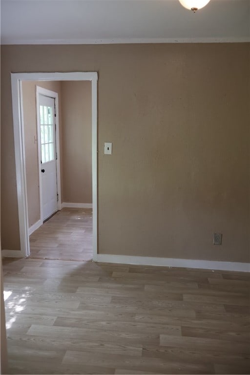 interior space with light wood-type flooring and crown molding