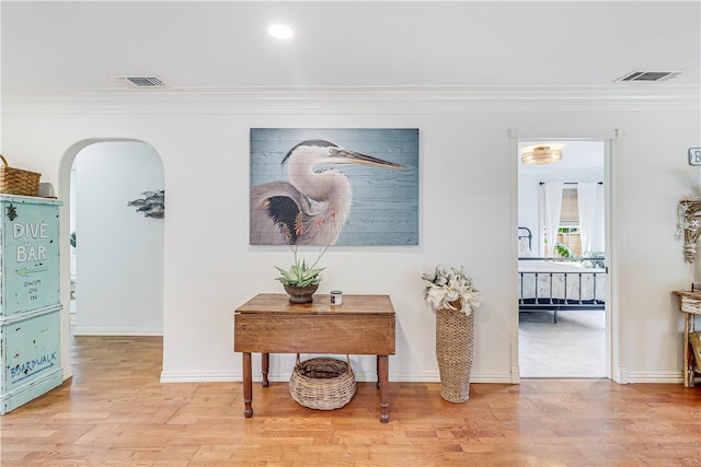 corridor with hardwood / wood-style floors and crown molding