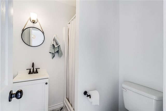 bathroom with toilet, vanity, and walk in shower