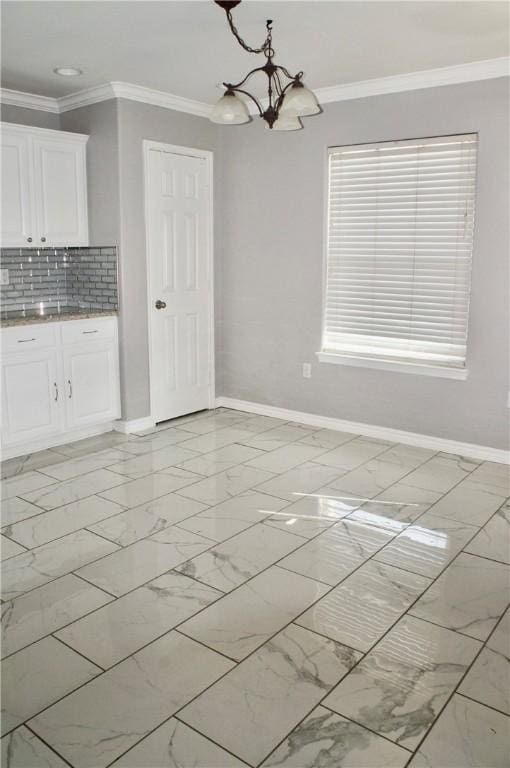 unfurnished dining area featuring crown molding and a chandelier