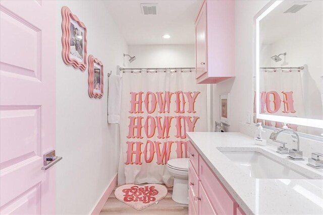 bathroom featuring vanity, a shower with shower curtain, toilet, and visible vents