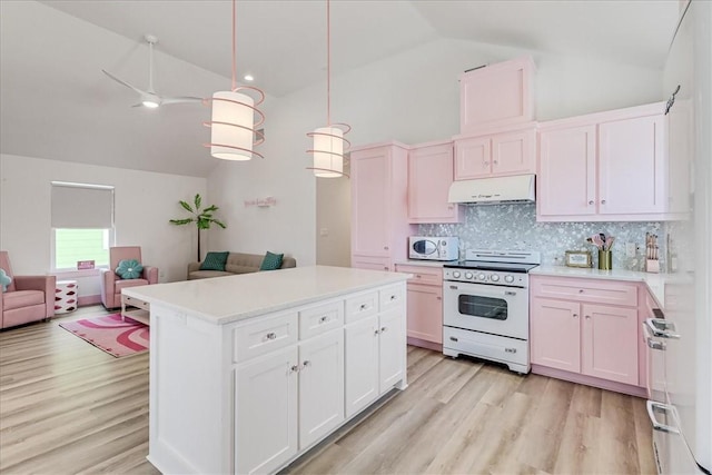 kitchen with decorative backsplash, white appliances, open floor plan, light countertops, and under cabinet range hood