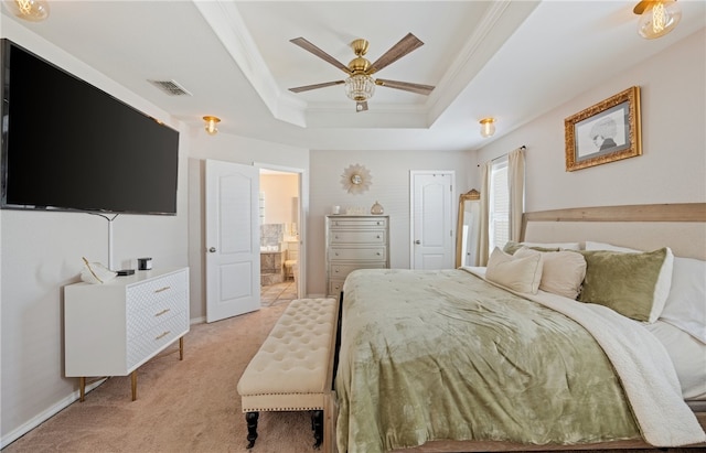 bedroom featuring light carpet, visible vents, ornamental molding, a tray ceiling, and ensuite bath