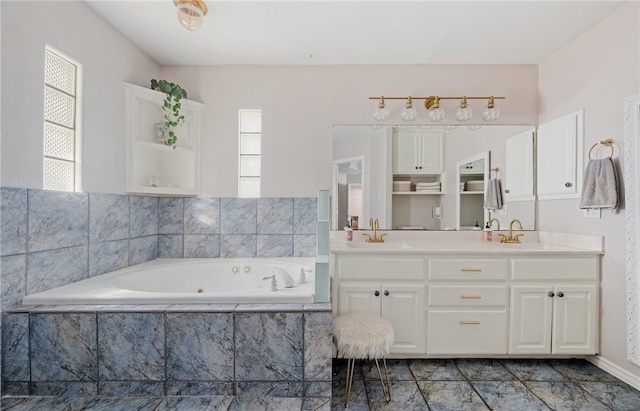 full bathroom with a whirlpool tub, double vanity, and a sink