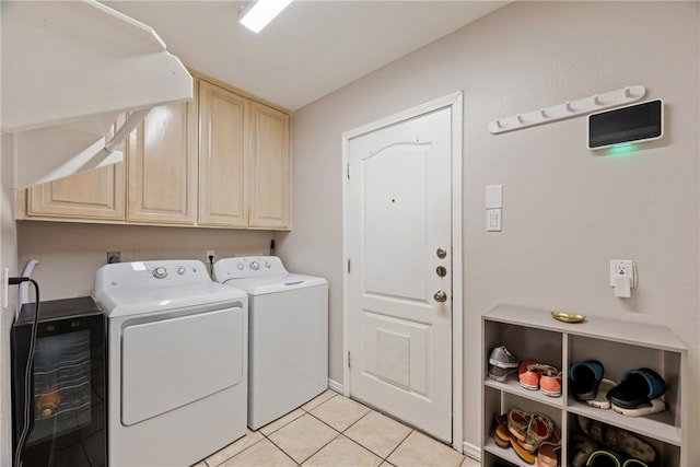 clothes washing area featuring cabinet space, light tile patterned floors, and washer and dryer