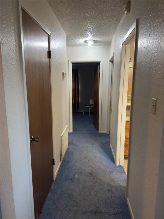 1203 N Hackberry St, Bishop, TX 78343 - corridor featuring a textured ceiling, a textured wall, and carpet