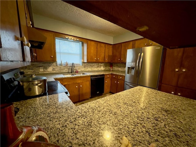 1203 N Hackberry St, Bishop, TX 78343 - kitchen featuring a textured ceiling, backsplash, a sink, black appliances, and brown cabinetry
